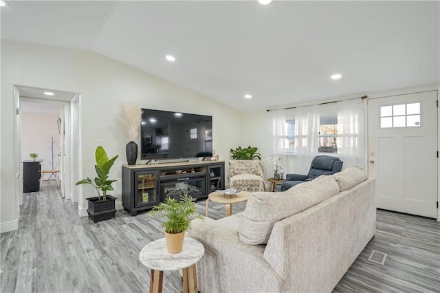 living room featuring lofted ceiling and light wood-type flooring