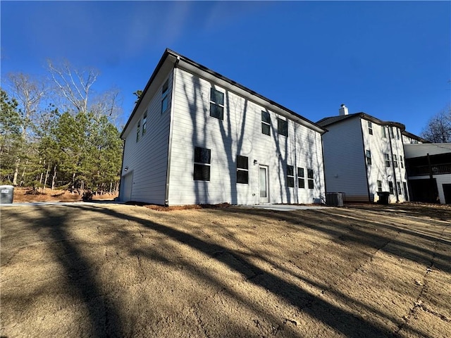 back of property with a garage and central air condition unit