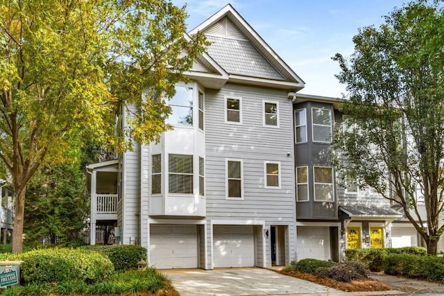 multi unit property featuring a garage and concrete driveway