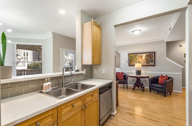 kitchen with a sink, backsplash, light countertops, and stainless steel dishwasher