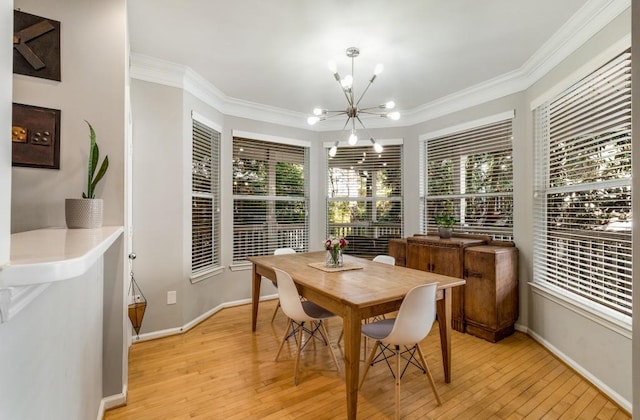 dining room with light wood-style floors, crown molding, baseboards, and an inviting chandelier