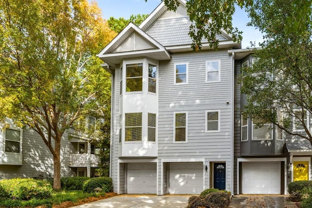 multi unit property featuring an attached garage and driveway