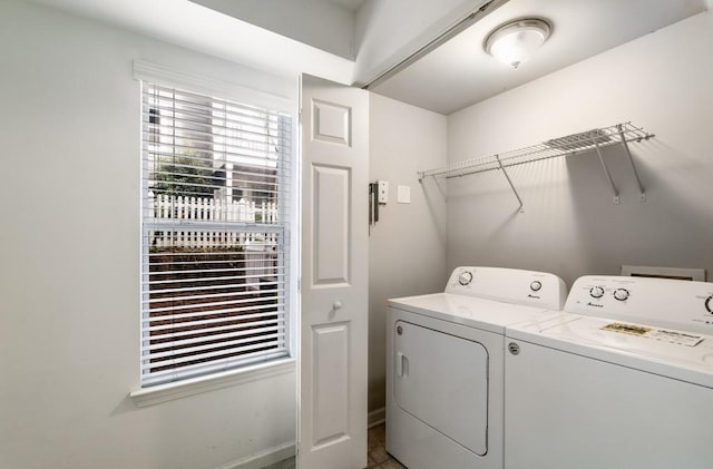 washroom with washing machine and dryer, laundry area, and baseboards