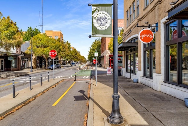 view of road with curbs, street lighting, traffic signs, and sidewalks