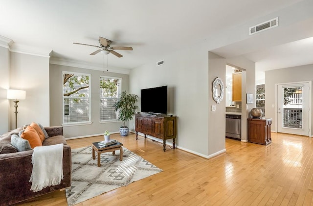 living room featuring light wood finished floors, baseboards, visible vents, and a ceiling fan