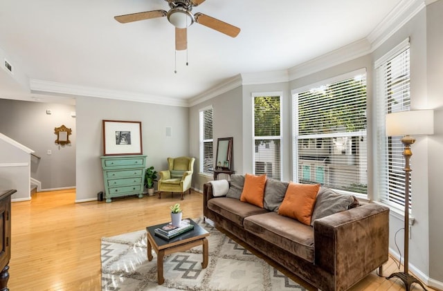 living room featuring light wood-style floors, visible vents, ornamental molding, and baseboards