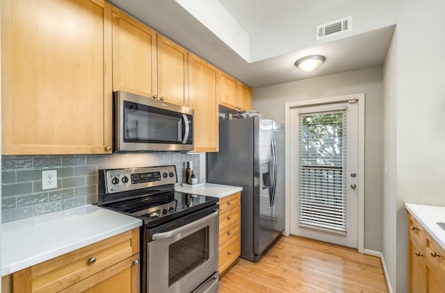 kitchen with stainless steel appliances, light countertops, and visible vents