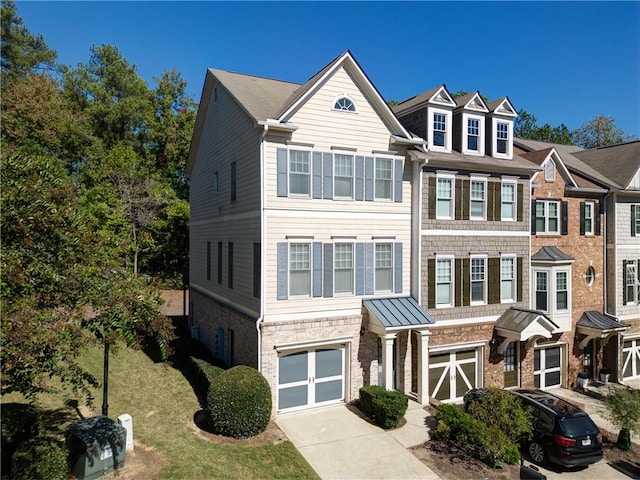 townhome / multi-family property featuring a front lawn and a garage