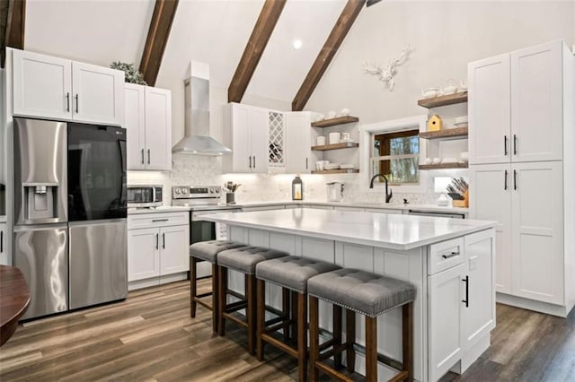 kitchen with open shelves, stainless steel appliances, light countertops, wall chimney exhaust hood, and tasteful backsplash