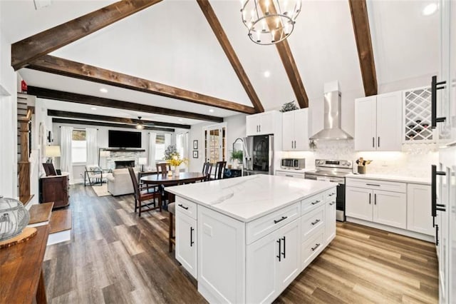 kitchen featuring stainless steel appliances, a fireplace, open floor plan, wall chimney exhaust hood, and tasteful backsplash