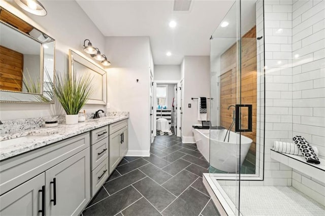 full bathroom featuring double vanity, a stall shower, visible vents, a freestanding bath, and a sink