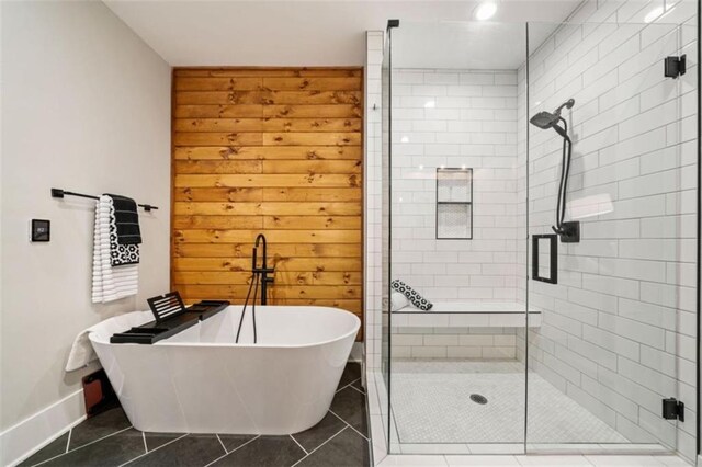 full bath featuring baseboards, a soaking tub, a shower stall, and tile patterned floors