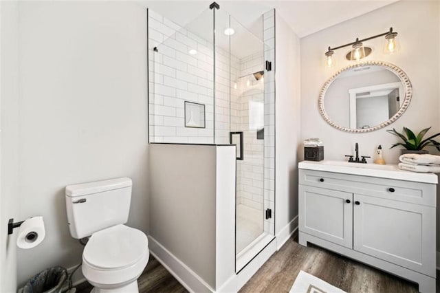 bathroom featuring a stall shower, baseboards, toilet, and wood finished floors