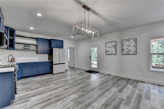 8305 Beryl Overlook, Gainesville, GA 30506 - kitchen featuring freestanding refrigerator, blue cabinets, open shelves, light countertops, and light wood-style floors