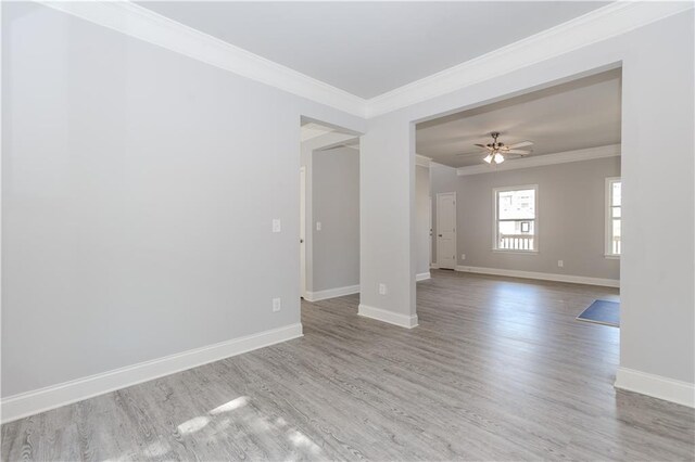 spare room with ornamental molding, wood finished floors, and baseboards