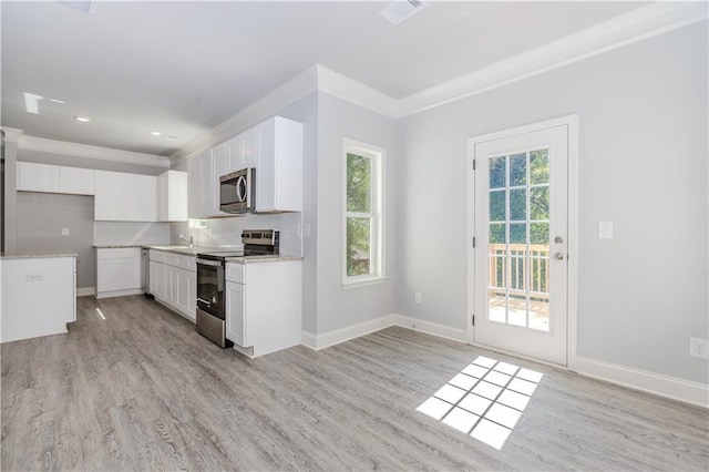 kitchen featuring a sink, visible vents, appliances with stainless steel finishes, decorative backsplash, and crown molding