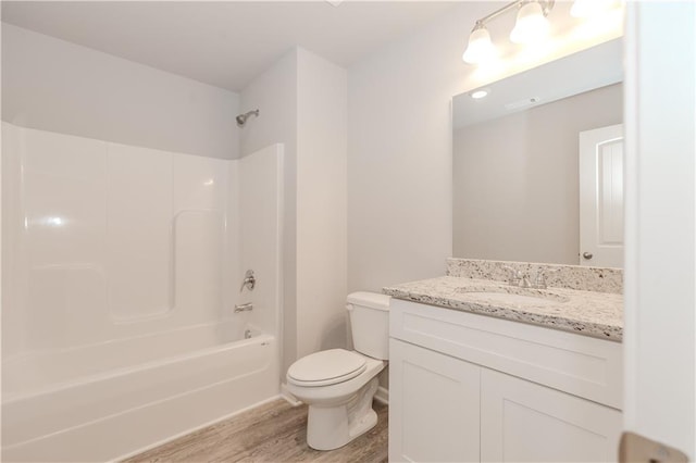 bathroom with vanity, bathing tub / shower combination, wood finished floors, and toilet