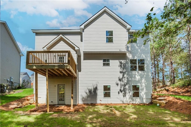 back of property with a wooden deck and a yard
