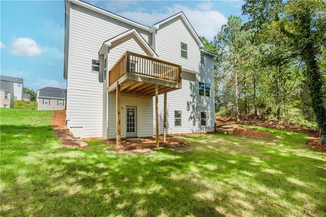 rear view of property with a wooden deck and a yard