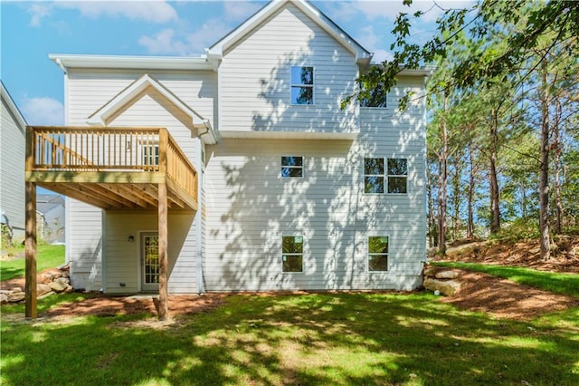 rear view of house featuring a yard and a wooden deck