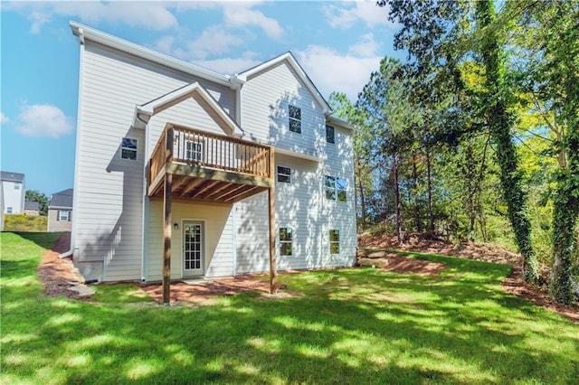 rear view of house with a lawn and a wooden deck