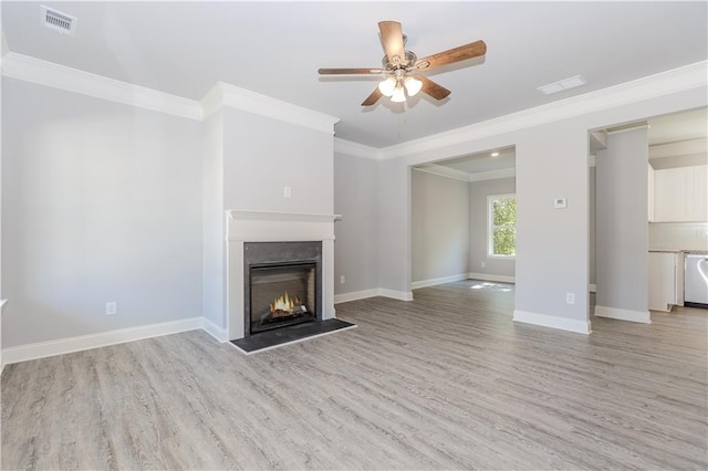 unfurnished living room with a warm lit fireplace, light wood-style flooring, visible vents, and baseboards