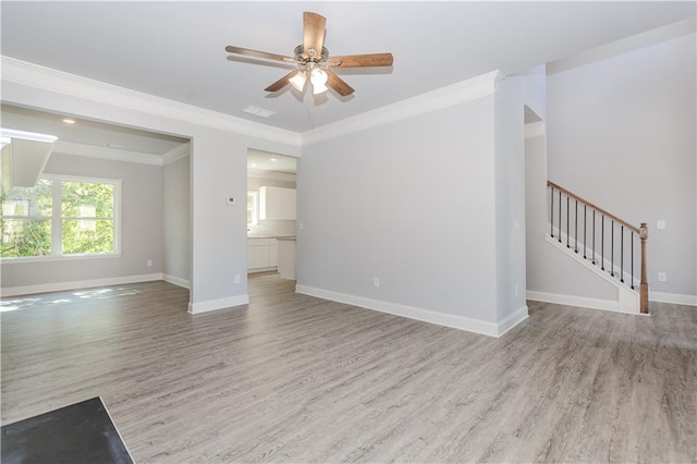 unfurnished living room with ceiling fan, ornamental molding, wood finished floors, and baseboards