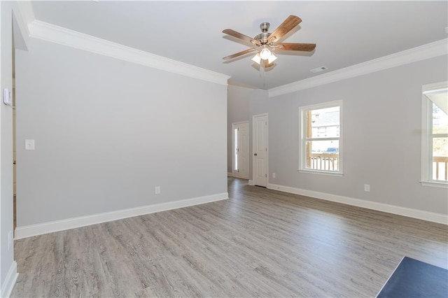 spare room featuring a ceiling fan, baseboards, ornamental molding, and wood finished floors