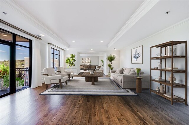 dining area featuring ornamental molding, a tray ceiling, wood finished floors, and a wainscoted wall