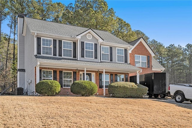 view of front of home with central AC, a porch, and a front yard