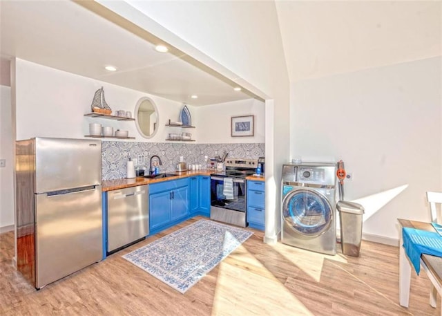 kitchen featuring blue cabinetry, open shelves, a sink, stainless steel appliances, and washer / dryer
