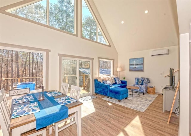 living area with a wall mounted air conditioner, high vaulted ceiling, wood finished floors, and recessed lighting