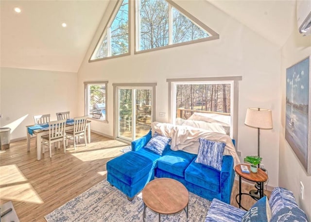 living area featuring baseboards, an AC wall unit, recessed lighting, wood finished floors, and high vaulted ceiling