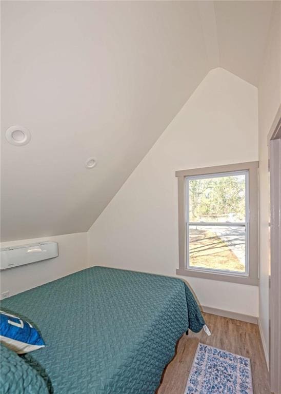 bedroom featuring lofted ceiling and wood finished floors