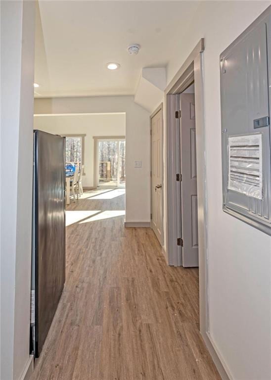 corridor featuring recessed lighting, baseboards, lofted ceiling, and wood finished floors