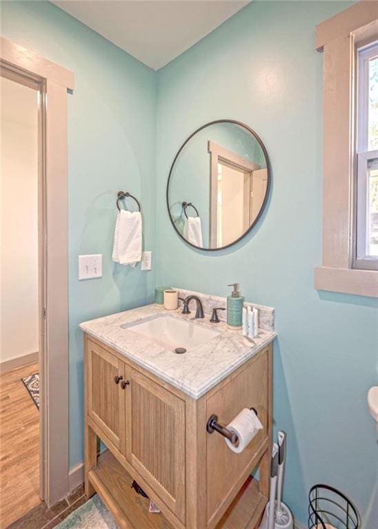 bathroom with vanity, wood finished floors, and baseboards