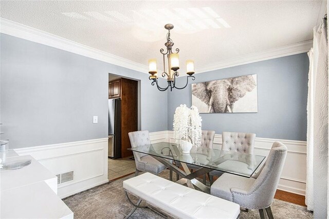 10 Callaway Ct, Hiram, GA 30141 - dining area featuring crown molding, a notable chandelier, visible vents, and a wainscoted wall