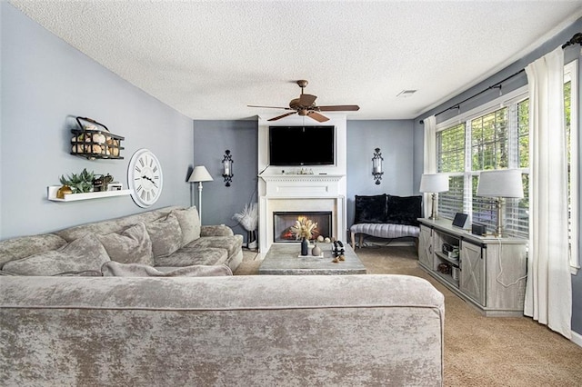 10 Callaway Ct, Hiram, GA 30141 - living room featuring a warm lit fireplace, a ceiling fan, a textured ceiling, and light colored carpet