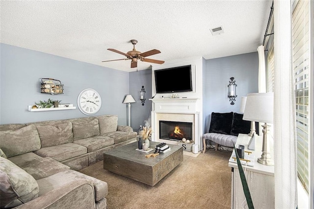 10 Callaway Ct, Hiram, GA 30141 - living room with a ceiling fan, a textured ceiling, light colored carpet, visible vents, and a glass covered fireplace