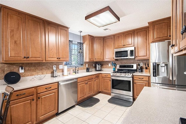 10 Callaway Ct, Hiram, GA 30141 - kitchen with backsplash, appliances with stainless steel finishes, brown cabinets, a sink, and light countertops