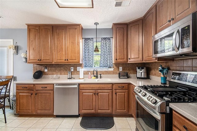 10 Callaway Ct, Hiram, GA 30141 - kitchen with a sink, a textured ceiling, brown cabinetry, stainless steel appliances, and visible vents