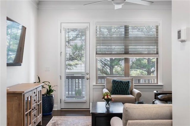 sitting room with ornamental molding, dark wood-type flooring, ceiling fan, and a healthy amount of sunlight