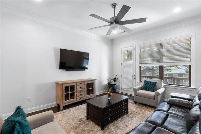 living room featuring wood-type flooring, ceiling fan, and crown molding