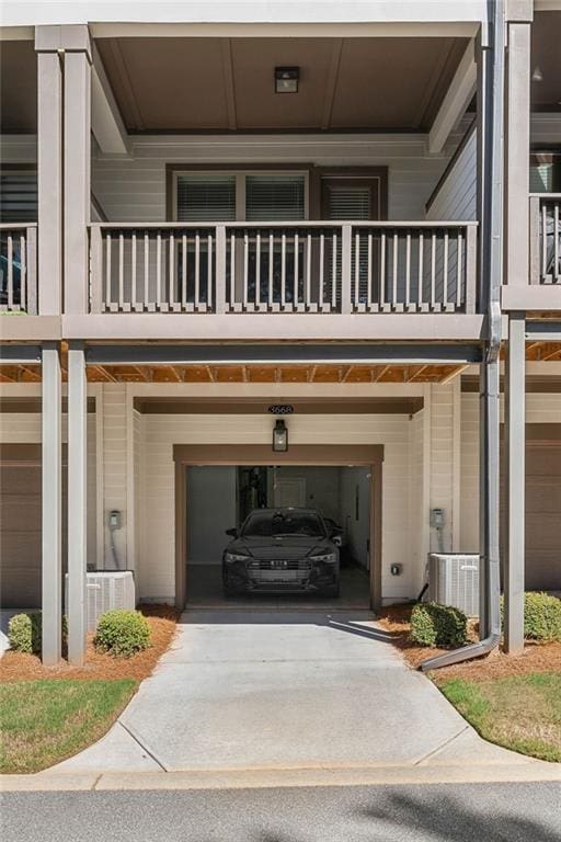 exterior space featuring a balcony, a garage, and central air condition unit