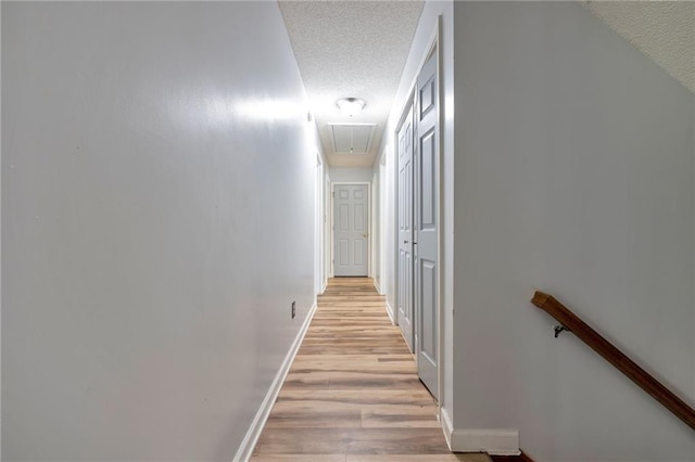 151 River Park Cir, Mcdonough, GA 30252 - hallway with attic access, a textured ceiling, light wood-style floors, and baseboards