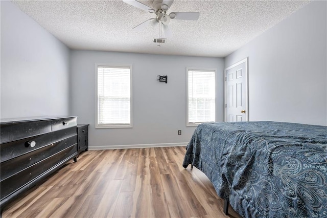 151 River Park Cir, Mcdonough, GA 30252 - bedroom with wood finished floors, multiple windows, a textured ceiling, baseboards, and a ceiling fan