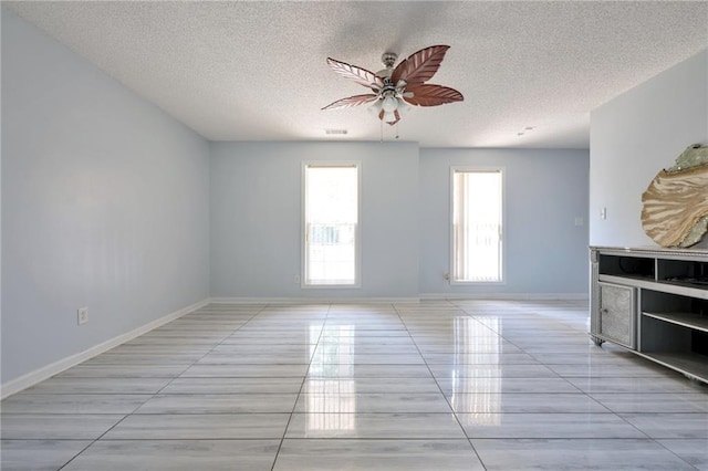151 River Park Cir, Mcdonough, GA 30252 - unfurnished living room with a textured ceiling, a ceiling fan, light tile patterned floors, and baseboards