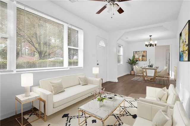 living room featuring ceiling fan with notable chandelier and hardwood / wood-style flooring