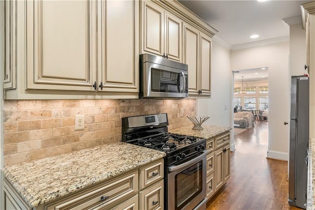 kitchen featuring cream cabinetry, dark hardwood / wood-style flooring, and stainless steel appliances