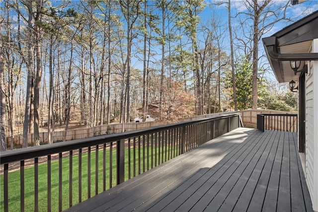 wooden terrace with a lawn and fence